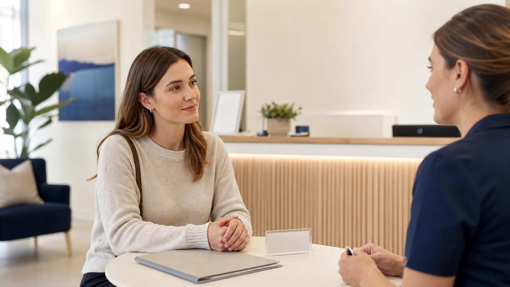 Personne échangeant avec une professionnelle de l'accueil dentaire avant de préparer ses questions d'assurance.